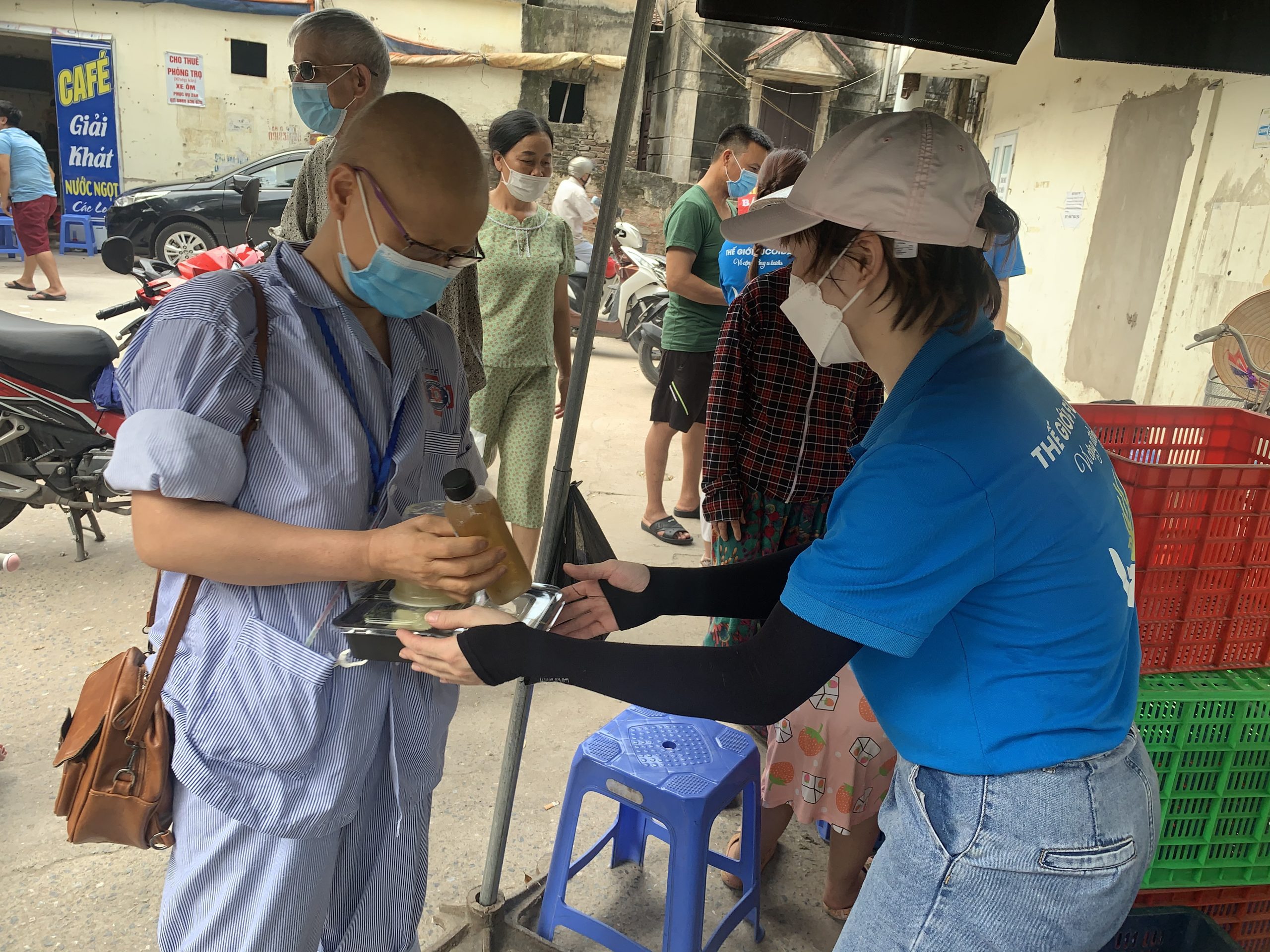 Các tình nguyện viên hỗ trợ chương trình phát cơm thiện nguyện tại cổng Bệnh viện K2